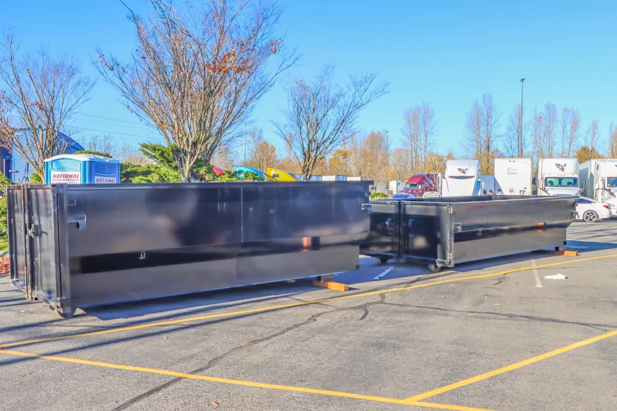 Professional dumpster rental service with roll-off container on residential driveway in Hattiesburg